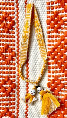 an orange and white rug with two tassels on it