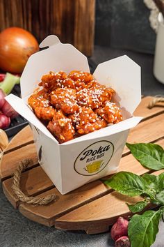 an open take out box filled with food on top of a cutting board