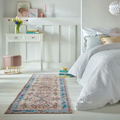 a bedroom with white walls and flooring has a rug on the floor next to it