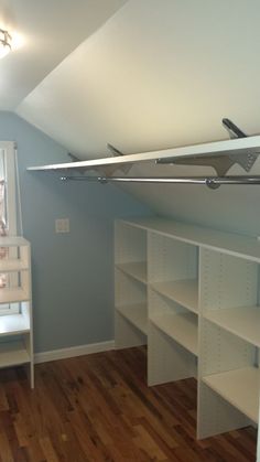 a baby's room with white shelves and blue walls