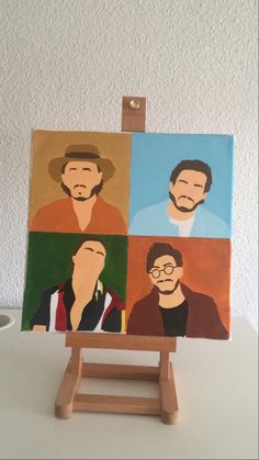 an easel with four paintings of men on it