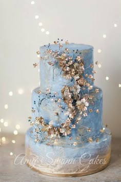 a blue wedding cake with gold flowers on top and the words instagram above it