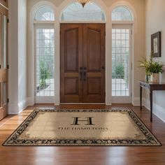 the entrance to a home with hardwood floors and large doors that lead into another room