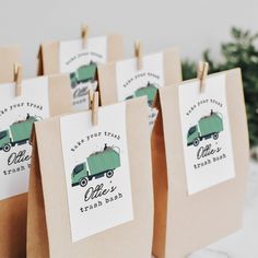 paper bags with green camper on them are hanging from clothes pins in front of a christmas tree