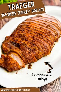 a white plate topped with sliced meat on top of a wooden table