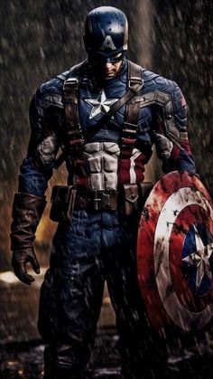 captain america is standing in the rain with his shield and helmet on, looking down