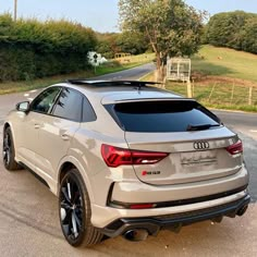 an audi suv is parked on the side of the road