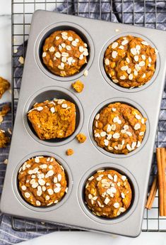 pumpkin muffins in a muffin tin with cinnamon sticks