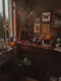 a room filled with lots of clutter and pictures on the wall next to a window