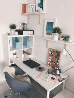 a white desk topped with a laptop computer next to a book shelf filled with books