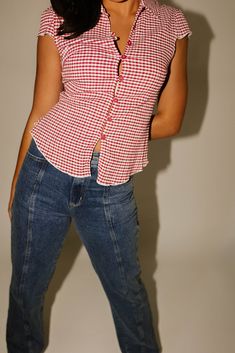 turn any casual outfit idea into a swirlie girlie slay with this collared red gingham button up top. it has a fitted bodice with dainty cap sleeves + vintage-inspired toggle buttons. the perfect summer // fall top to pair with jeans + sneakers, or a mini skirt + loafers. cherry // collared, buttons, cap sleeves, darts, fitted waist paired with our florida denim model is 5'8" + wearing a small measurements are approximate + taken while laying flat small : bust 32” length 22” medium : bust 34” len Summer Gingham Button-up Tops, Summer Gingham Top With Buttons, Summer Gingham Top With Button Closure, Gingham Summer Tops With Buttons, Fitted Plaid Top For Picnic, Trendy Red Tops For Picnic, Fitted Retro Tops For Picnic, Retro Fitted Tops For Picnic, Retro Gingham Top With Button Closure