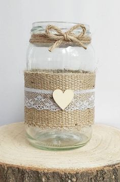 a mason jar filled with burlock and a heart on the lid sitting on top of a tree stump