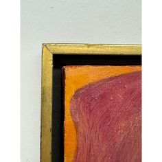 an abstract painting in a gold frame on a white wall next to a red and orange piece of artwork