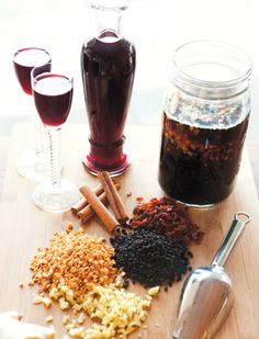 there are several different types of spices on the table next to wine glasses and spoons