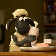 a cartoon sheep is sitting at a table