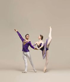 two ballerinas in purple and white are posing for the camera with their arms outstretched