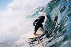 a man riding a wave on top of a surfboard