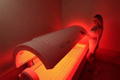 a woman standing next to a red light in a room