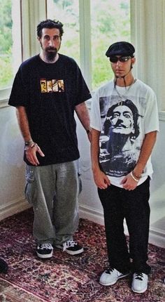 two young men standing next to each other in front of a window with an area rug on the floor