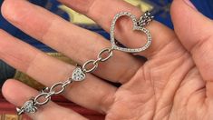 This lovely fancy link bracelet features diamond accented heart links and a mix of chain styles. The large open heart link is framed with thirty-two (32) round brilliant cut diamonds that are all prong set. The two (2) puffed heart links are each accented on each side with six (6) pavé set, round brilliant cut diamonds. One section of the bracelet features two strands of 3.6mm Rolo chain and the other side of the bracelet are 5.9mm wide oval shaped links. The bracelet fits up to a 7 inch wrist a Diamond Chain Bracelet, Puffed Heart, Heart Diamond, Diamond Chain, Open Heart, Rolo Chain, Garnet Rings, Diamond Heart, Round Brilliant Cut Diamond