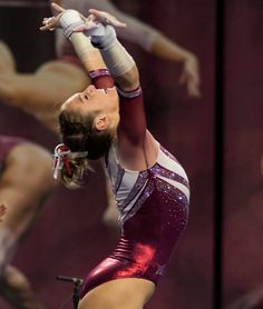 a woman is performing on the balance beam