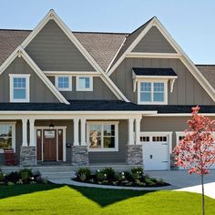 a house with two garages and lots of windows on the front side of it