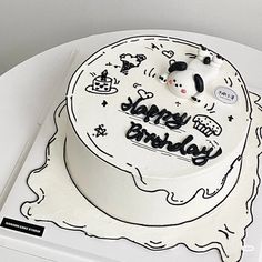 a white birthday cake with black writing on it