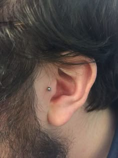 an ear piercing is seen in this photo taken from behind the head of a person