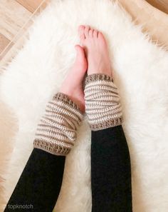 a woman's legs wearing knitted arm warmers on top of a white rug