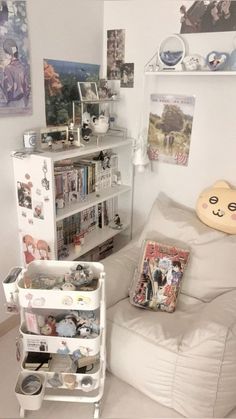 a white couch sitting next to a bookshelf filled with lots of books and toys