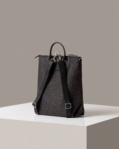 The Bedford Backpack's unique three-way design shows off the sculptural quality of felt as well as Merino wool felt's natural durability. Detachable straps convert the Bedford from backpack (https://graflantz.com/collections/backpack) to shoulder tote in seconds. Features include an interior zippered felt pocket, smooth leather trim, and nickel hardware.

 Also available in a mini (https://graf-lantz.com/products/bedford-backpack-mini-granite-felt-sienna-leather) version for a smaller frame or lighter load

 To add a little extra flare and make your bag even more unique, why not add one of our Fobs (https://graflantz.com/collections/keychains).

 
*Please Note: Gift Boxes are not available for this item



 Benefits of Merino Wool Felt

  
 * Sustainable, biodegradable, and renewable 
 * O Felt Backpack, Graf Lantz, Unique Backpacks, Convertible Bags, Nickel Hardware, Small Frame, Shoulder Tote, Vegetable Tanned Leather, Black Charcoal