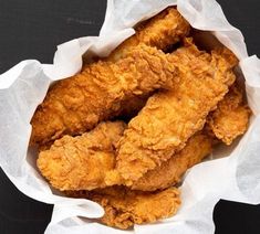 fried chicken in a paper bag on a black surface