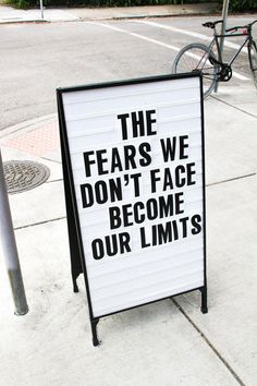 a sign on the sidewalk that says, the fears we don't face become our limits