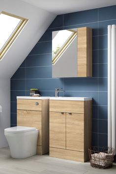 a bathroom with blue walls and white fixtures, including a toilet in the corner under a slanted skylight