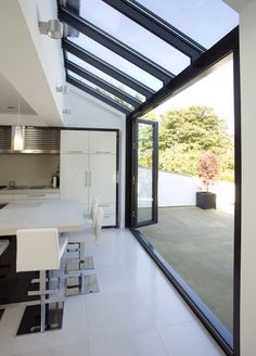 an open kitchen and dining room with glass walls