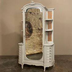 an antique white armoire with a mirror on it's front and side shelves