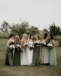 a group of women standing next to each other on top of a lush green field