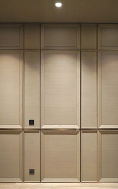 an empty room with beige walls and wooden paneling on the wall is lit by recessed lights