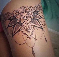 a woman's thigh with an intricate tattoo design on the side of her leg