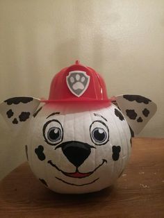 a pumpkin with a fireman's hat on it and a dog face painted on the top