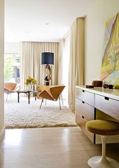 a living room filled with furniture and a painting on the wall next to a window