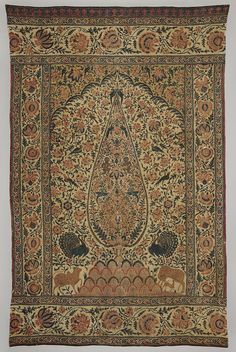 an intricately decorated carpet with animals and flowers on the border, is displayed in front of