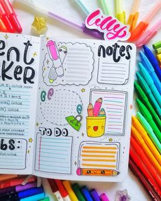 an open notebook with writing on it and colorful markers next to the pages that are lined up