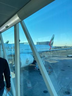 a man standing in front of an airport window