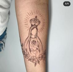 a tattoo on the arm of a woman with a crown and flowers around her ankles