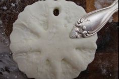 a silver spoon sitting on top of a white piece of food