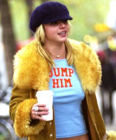 a woman walking down the street with a cup in her hand