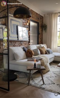 a living room filled with furniture and a brick wall