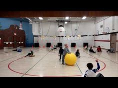 several people in a gym playing with large balls