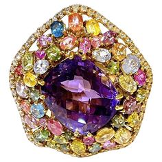 Bochic "Orient” Amethyst & Fancy Multi Sapphire Large Cocktail Ring 18K Gold & Silver Natural Purple Amethyst - 9 Carat Natural Fancy Sapphire from Sri Lanka - 5 Carat Colors: Blue, light Blue, Orange, Green, Yellow, Red, Pink, Rose, Llilc White Topaz - 1 Carat This Ring is from the "Orient" traveling collection are the epitome of elegance and versatility. It offers a perfect blend of day to night and swimwear to evening wear, allowing you to effortlessly transition between different occasions a Luxury Multicolor Amethyst Gemstone Ring, Luxury Multicolor Amethyst Ring With Gemstone Accents, Multicolor Luxury Amethyst Ring, Luxury Multicolor Amethyst Ring For Formal Occasions, Multicolor Luxury Amethyst Ring For Formal Occasions, Luxury Multicolor Amethyst Ring As Gift, Luxury Multicolor Amethyst Ring Gift, Luxury Multicolor Amethyst Gemstones, Luxury Multicolor Amethyst Ring For Gift